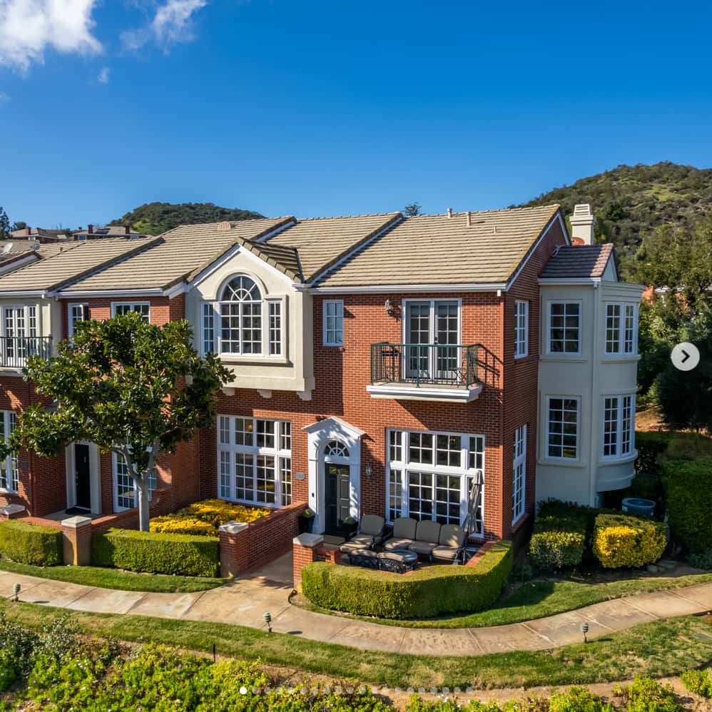 Luxury brick mansion with lush green landscaping