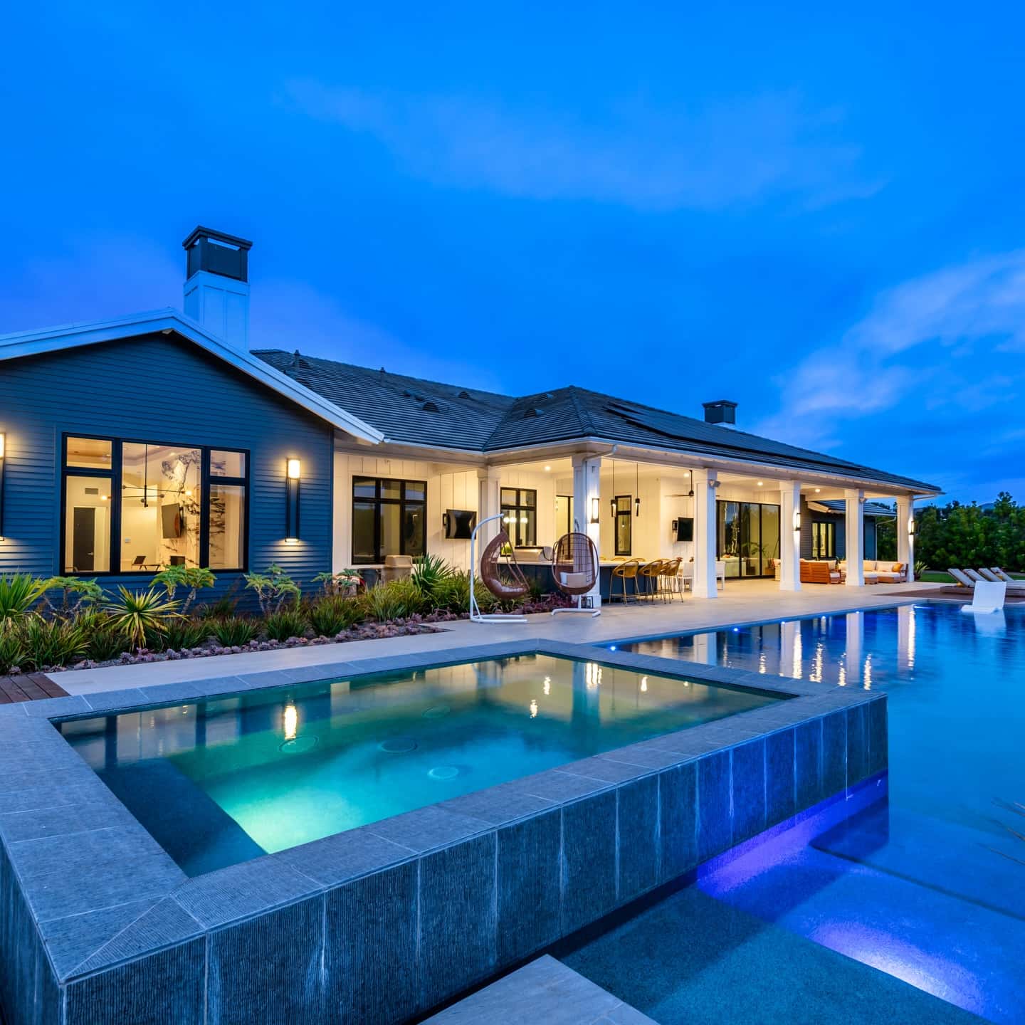 Modern luxury home with infinity pool at twilight