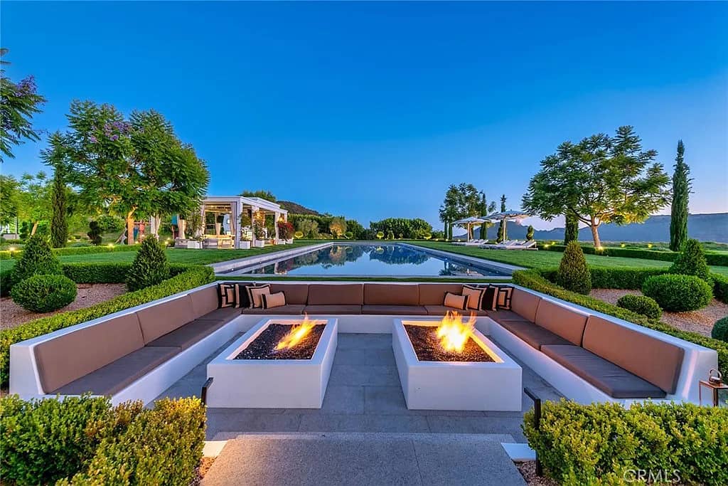 Elegant pale stone mansion exterior with symmetrical windows and manicured grounds